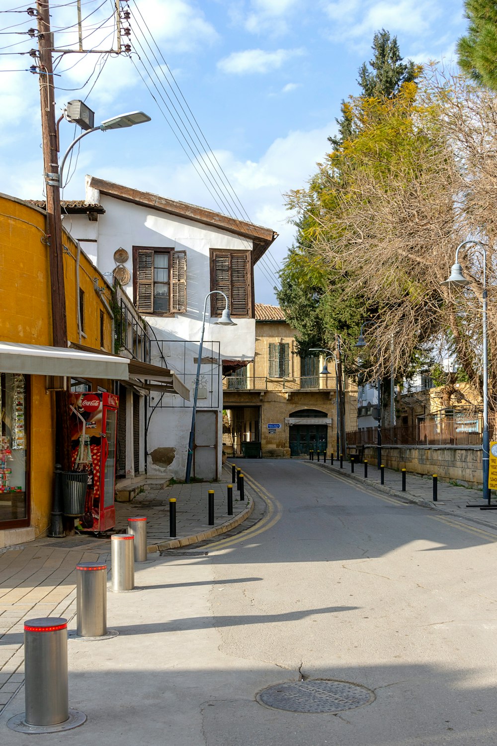 yellow and white concrete building near bare trees during daytime