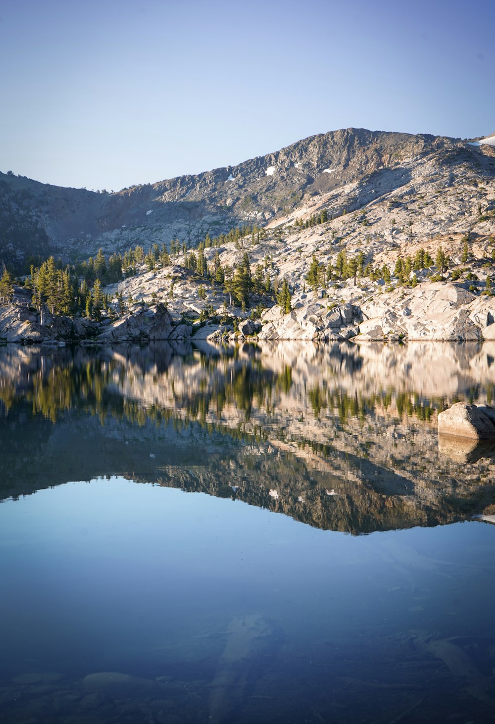 green and brown mountain near body of water during daytime