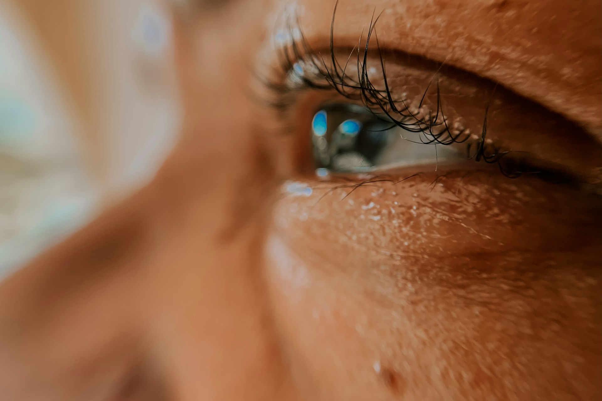 An intimate close-up showing the warmth and spark in someone's eyes, hinting at the stories behind their smile.