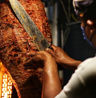person holding sliced meat during daytime