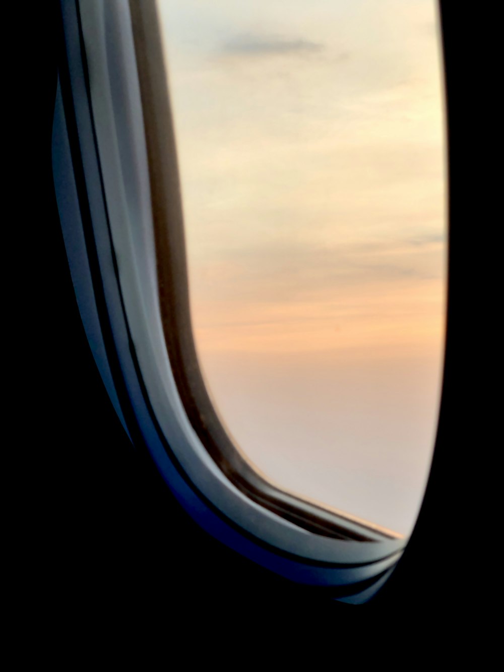 airplane window view of clouds during sunset