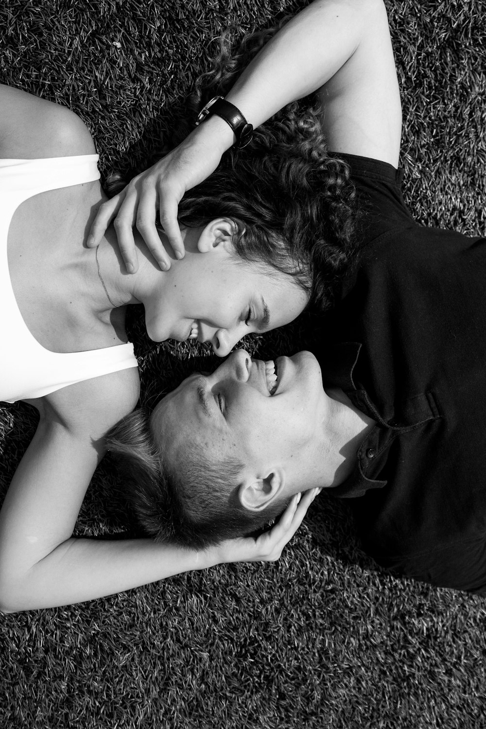 man in white tank top lying on black textile