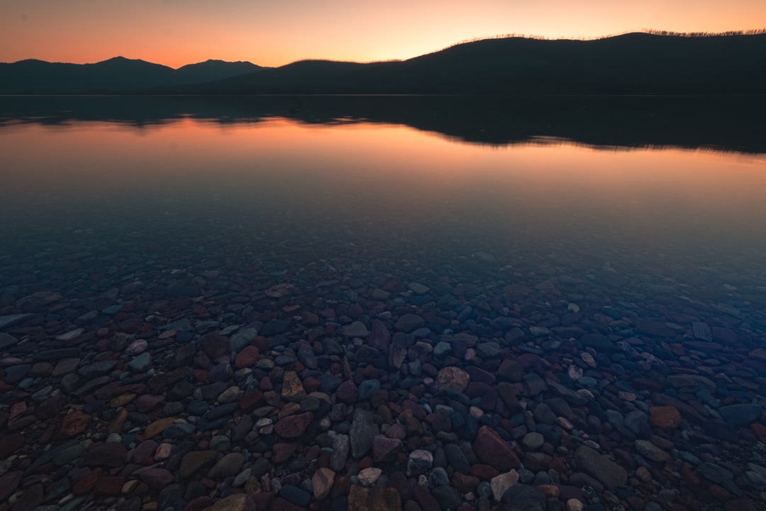 body of water near mountain during daytime