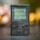 A vintage handheld gaming device displaying the iconic game Tetris on its screen. The device is a Nintendo Game Boy Pocket, featuring a sharp, rectangular form with a D-pad, buttons, and a small speaker. The screen shows a classic pixelated title screen design.