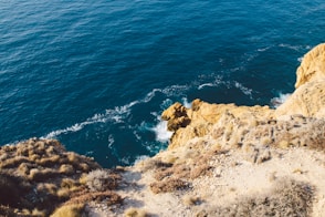 brown rock formation beside blue sea during daytime
