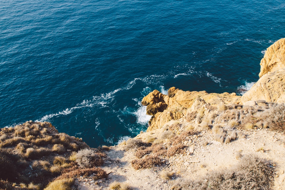 brown rock formation beside blue sea during daytime