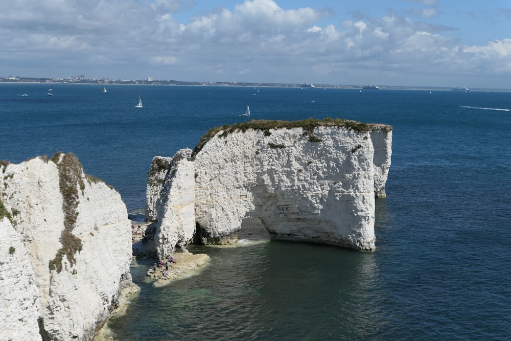 Un groupe de personnes debout au sommet d’une falaise au bord de l’océan