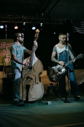 man in white shirt playing electric guitar