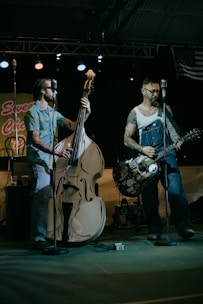 man in white shirt playing electric guitar