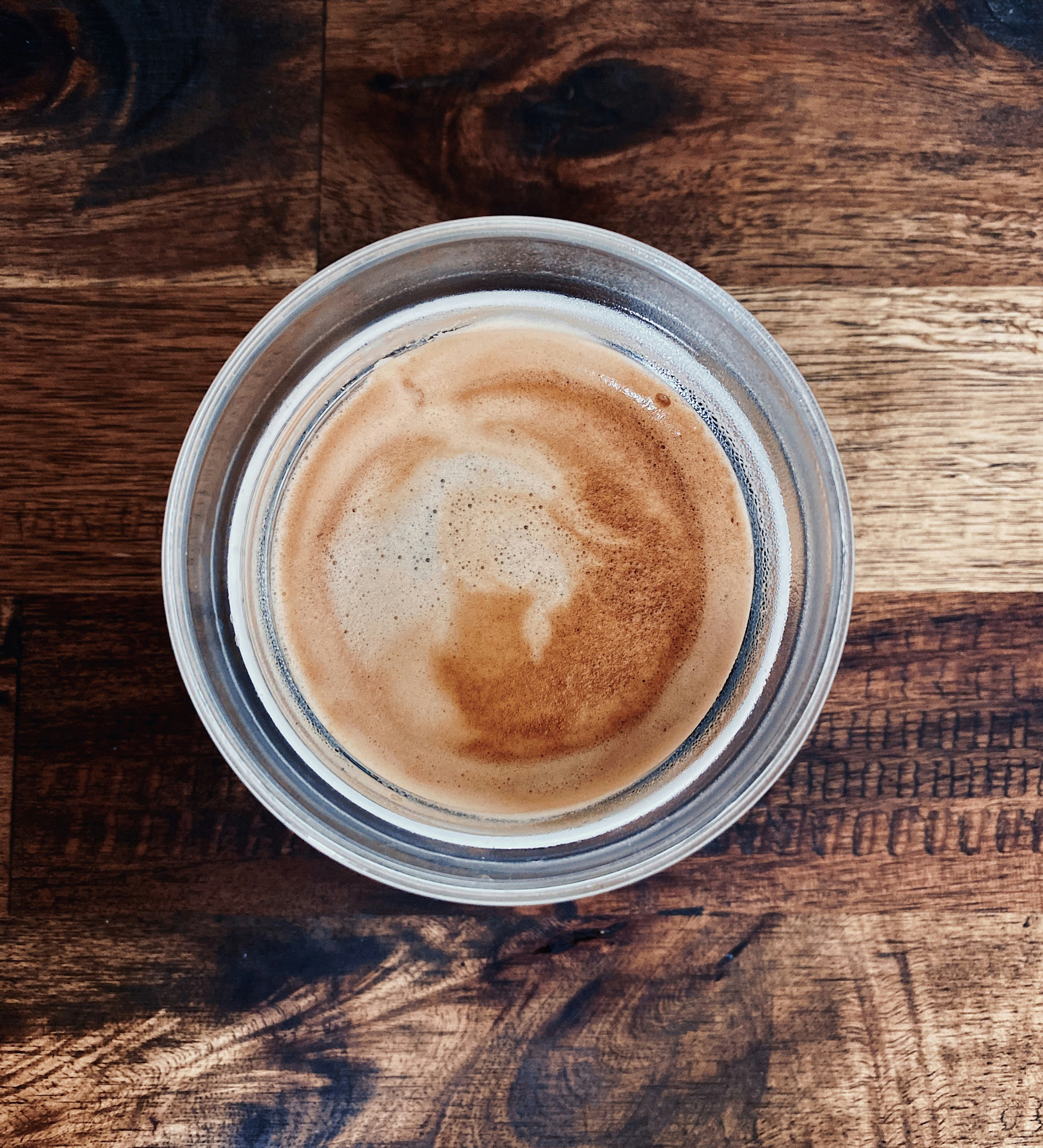 Light coffee with vanilla cream, soft warm light, delicate cup on wooden surface