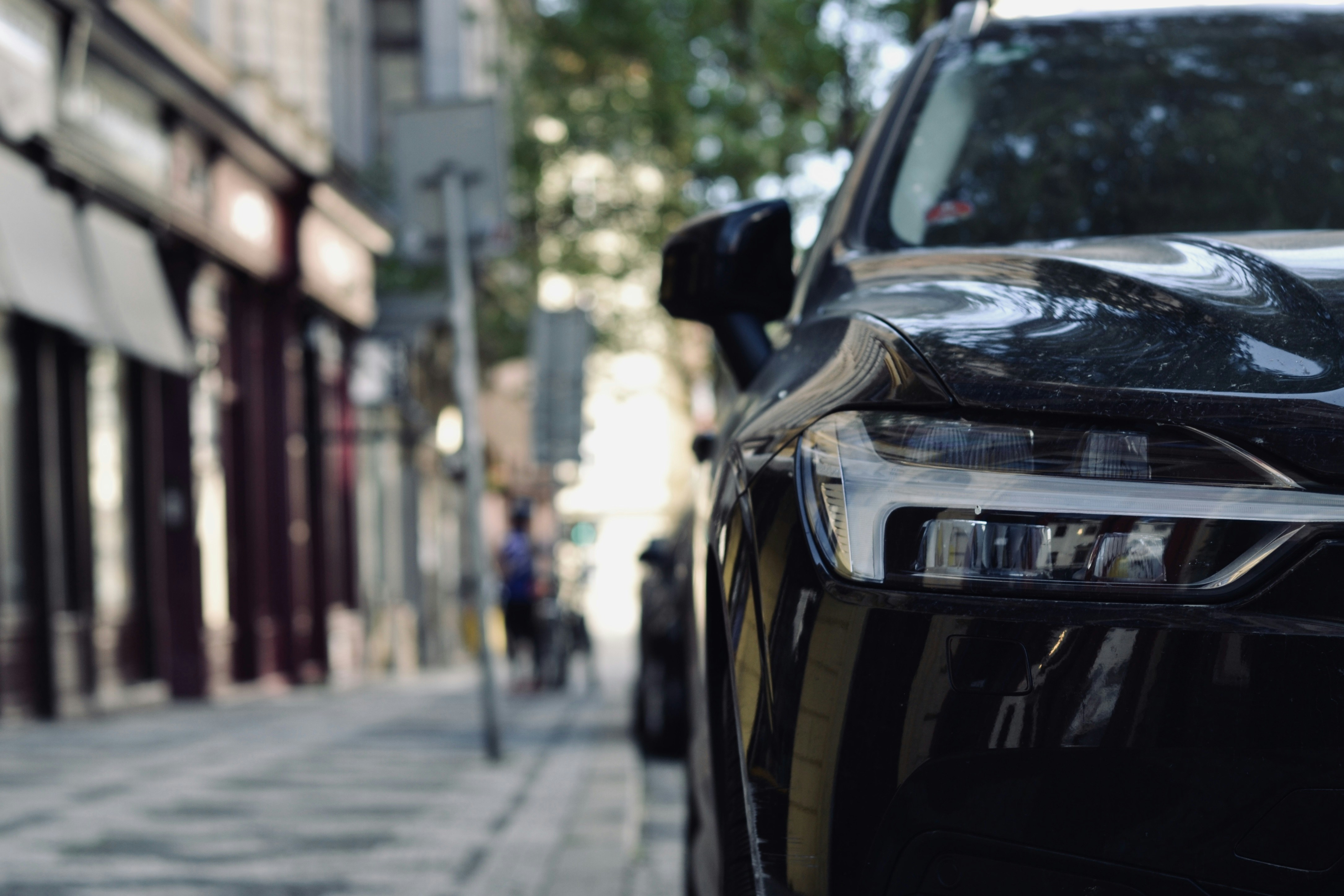black car parked on sidewalk during daytime