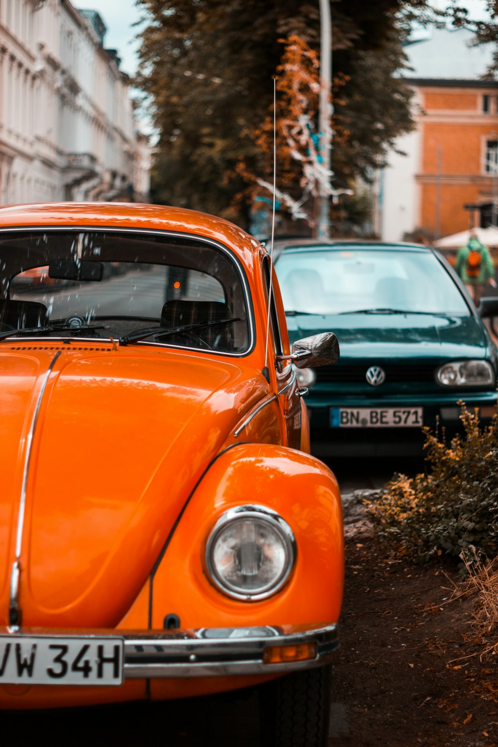 orange volkswagen beetle parked on green grass field during daytime