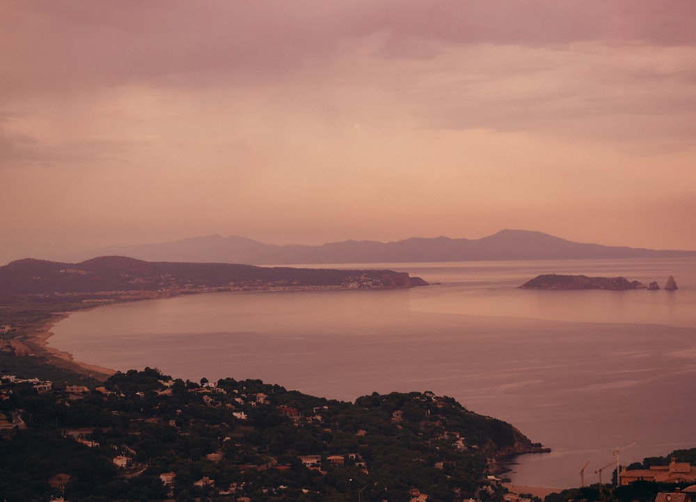 body of water near mountain during daytime