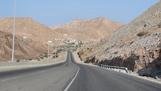 gray asphalt road between brown mountains during daytime