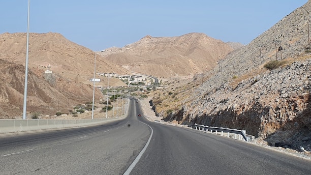 gray asphalt road between brown mountains during daytime