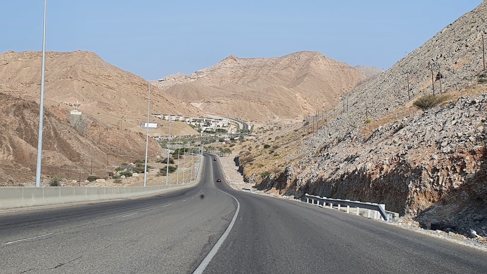 Strada asfaltata grigia tra le montagne marroni durante il giorno