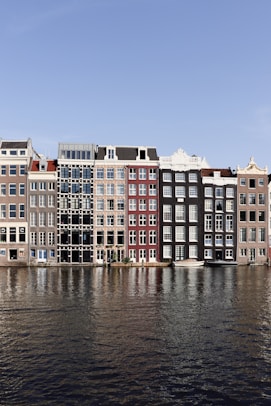 brown and white concrete building beside body of water during daytime
