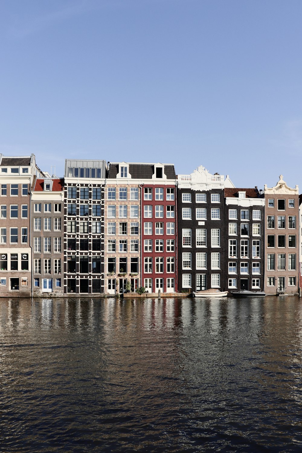 brown and white concrete building beside body of water during daytime