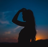 silhouette of woman covering her face with her hands