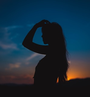 silhouette of woman covering her face with her hands