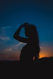 silhouette of woman covering her face with her hands