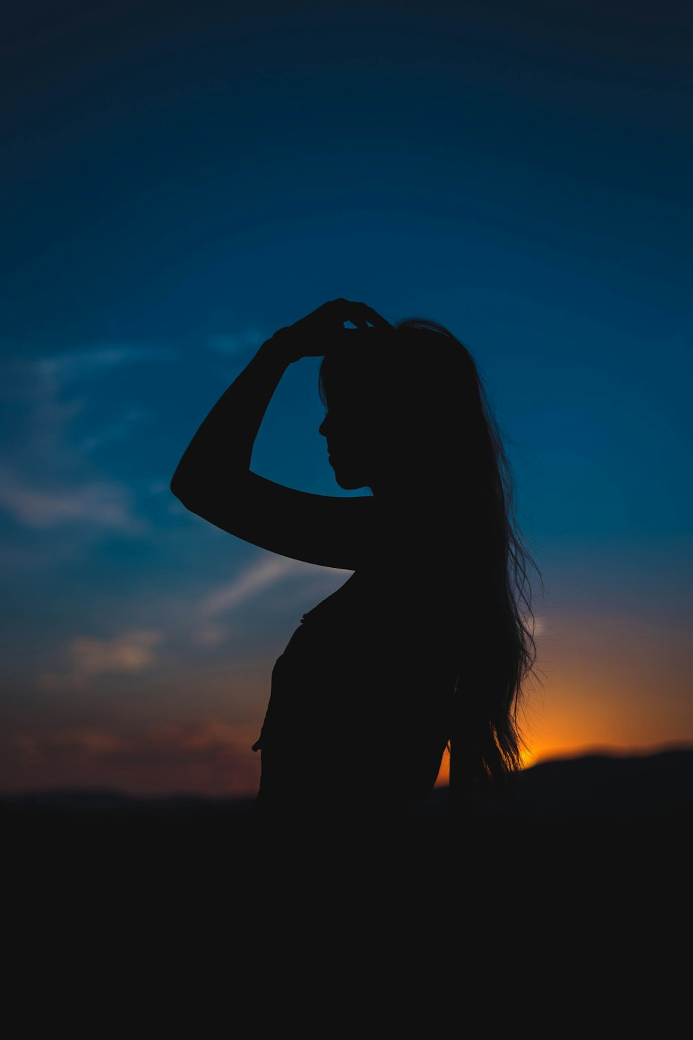 silhouette of woman covering her face with her hands