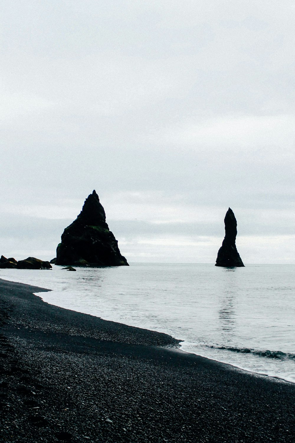 black rock formation on sea during daytime