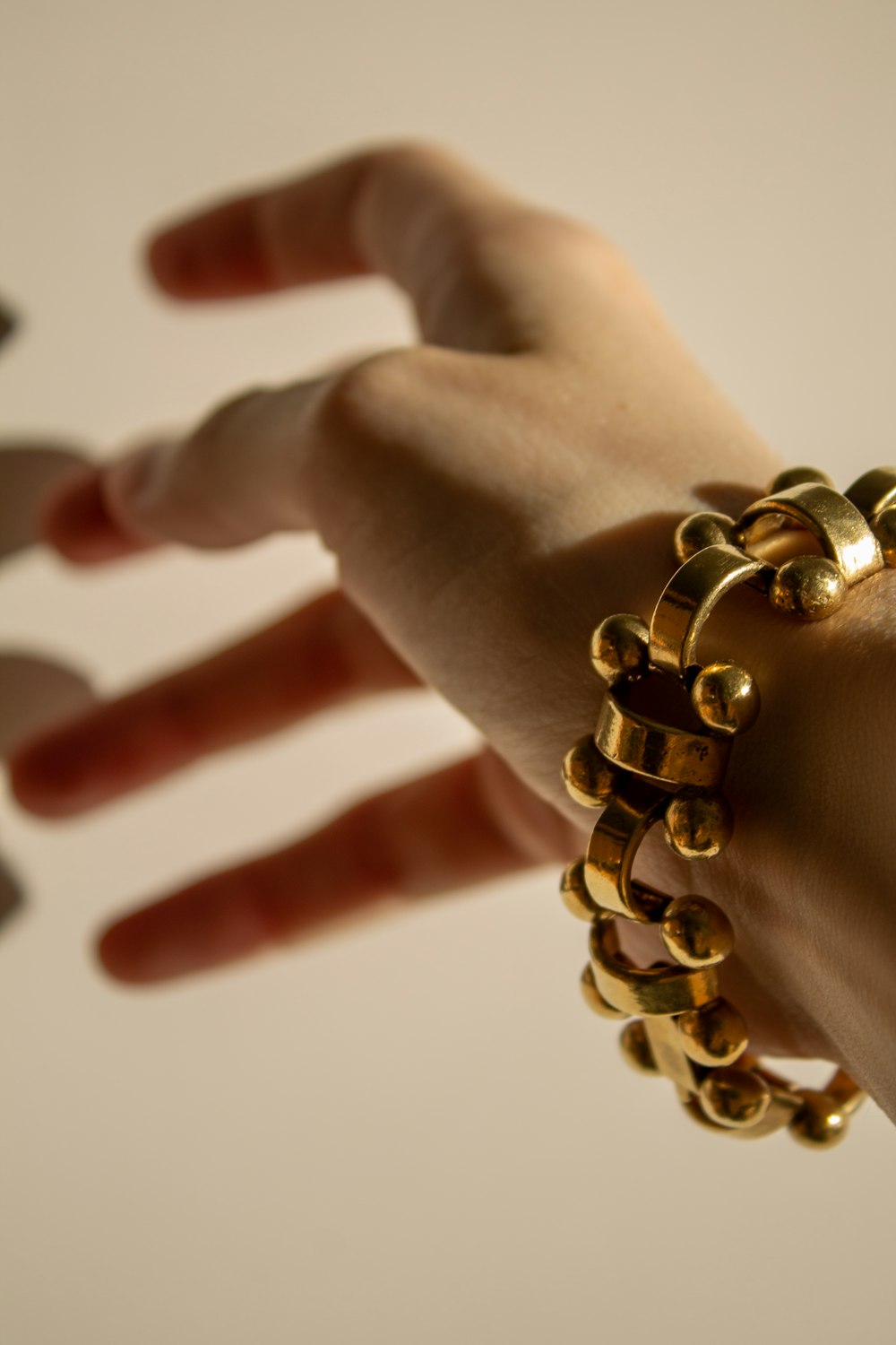 gold beaded bracelet on persons hand