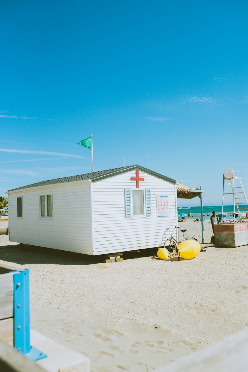 white and red wooden house on beach during daytime