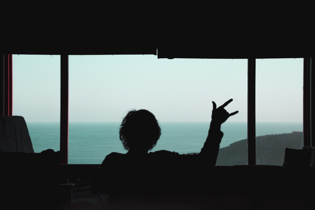 silhouette of woman sitting on bench during sunset