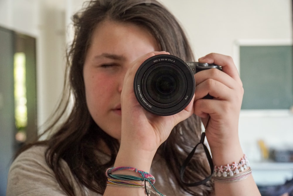 Frau mit schwarzer Kamera beim Fotografieren