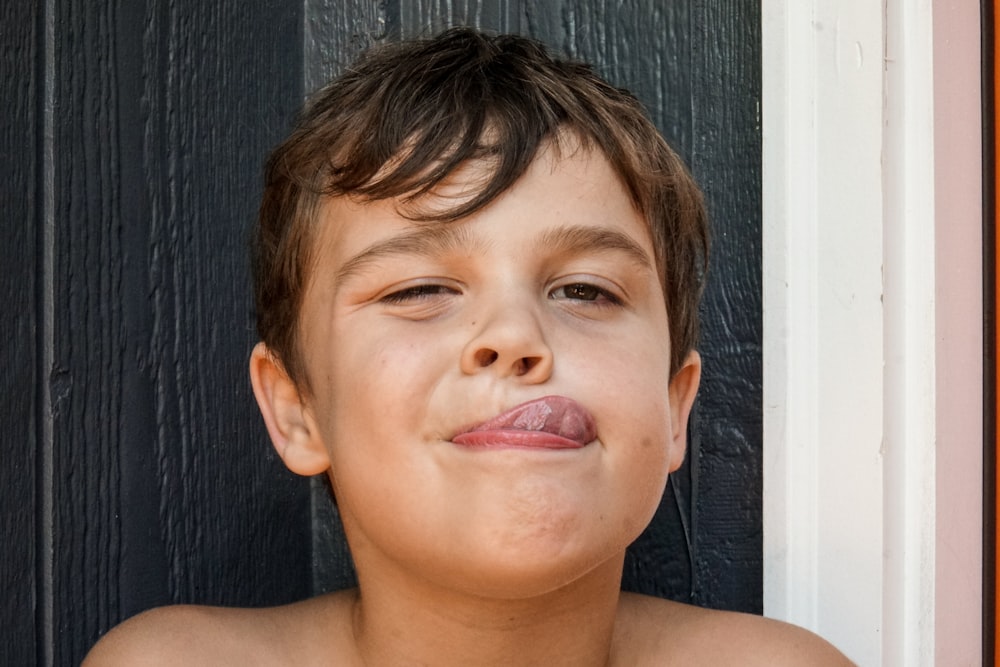 Junge mit braunen Haaren und rotem Lippenstift