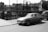 grayscale photo of classic car parked near building