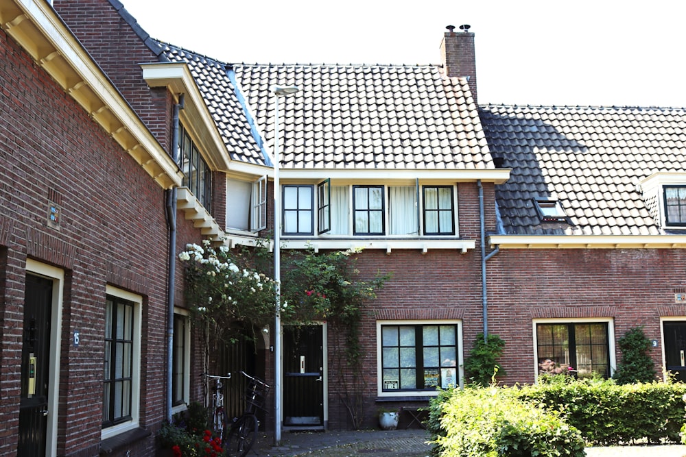 Maison en briques brunes avec des plantes vertes