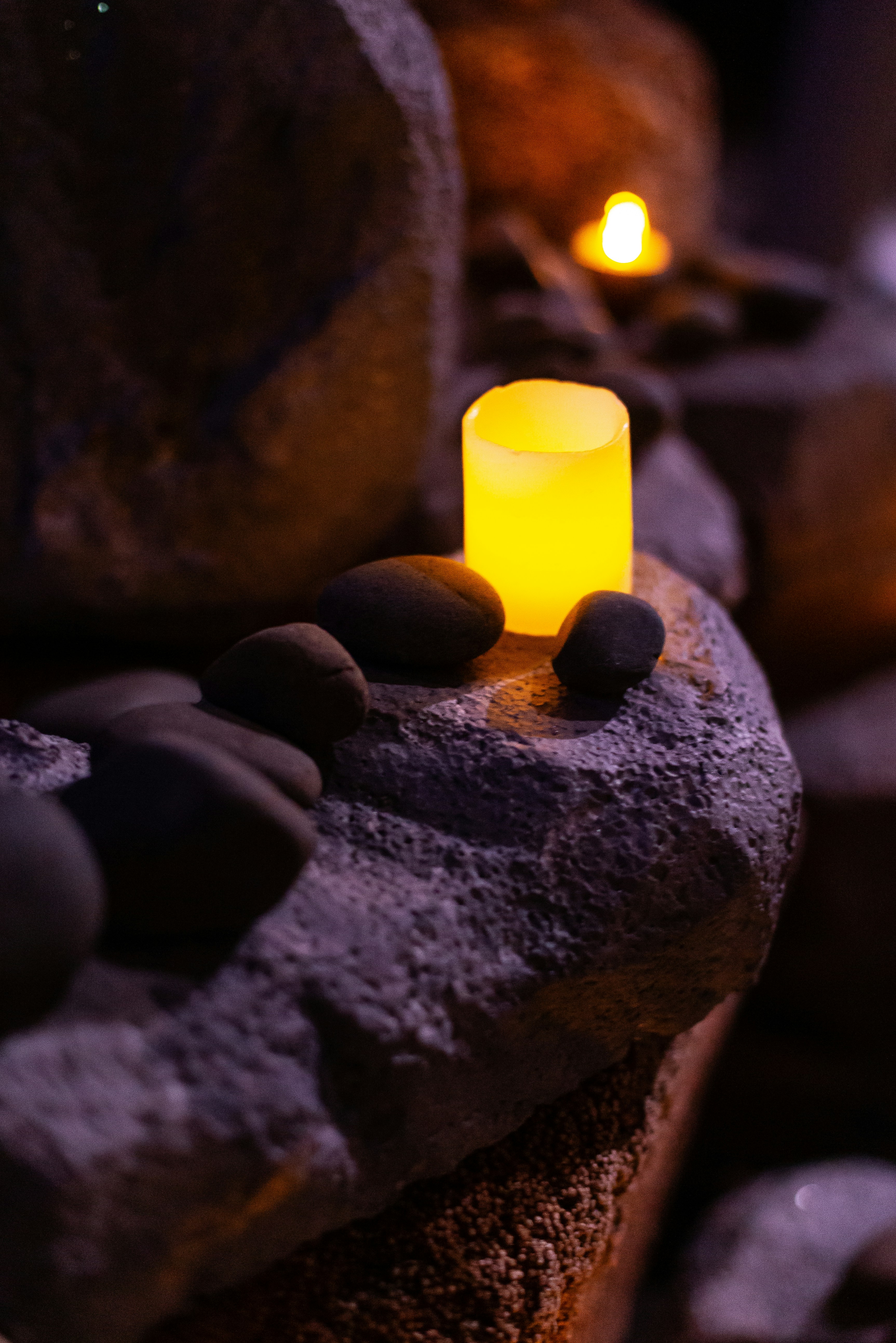 yellow pillar candle on gray rock