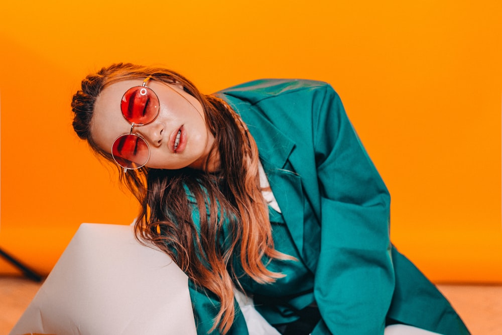 woman in blue blazer wearing red framed sunglasses