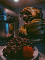 Modern kitchen countertop featuring a stylish blender next to fresh fruits and a recipe book.