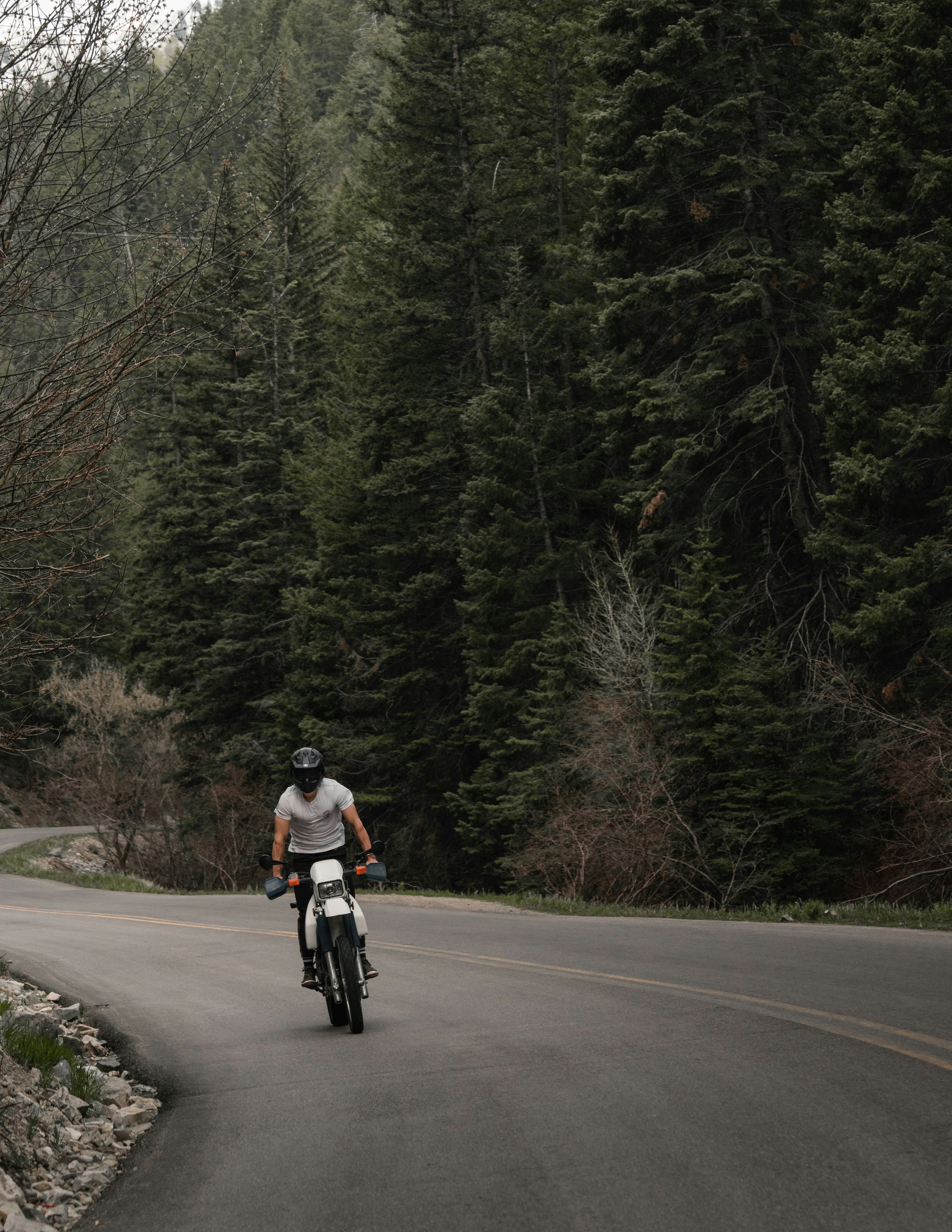 man in white shirt riding bicycle on road during daytime