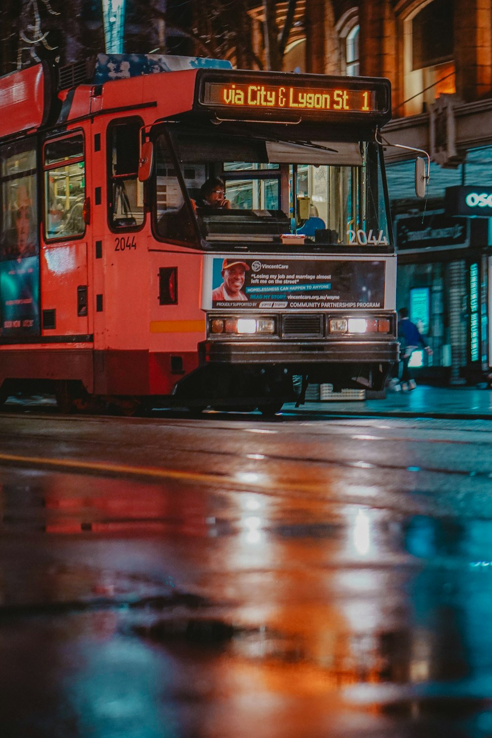 red and black train on the street during night time