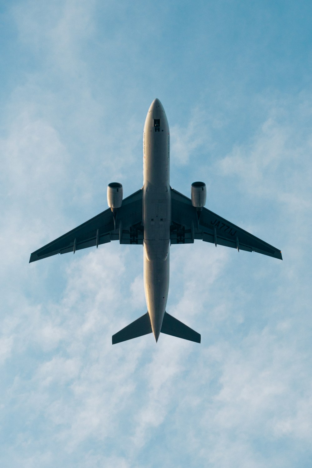 white airplane under white clouds during daytime