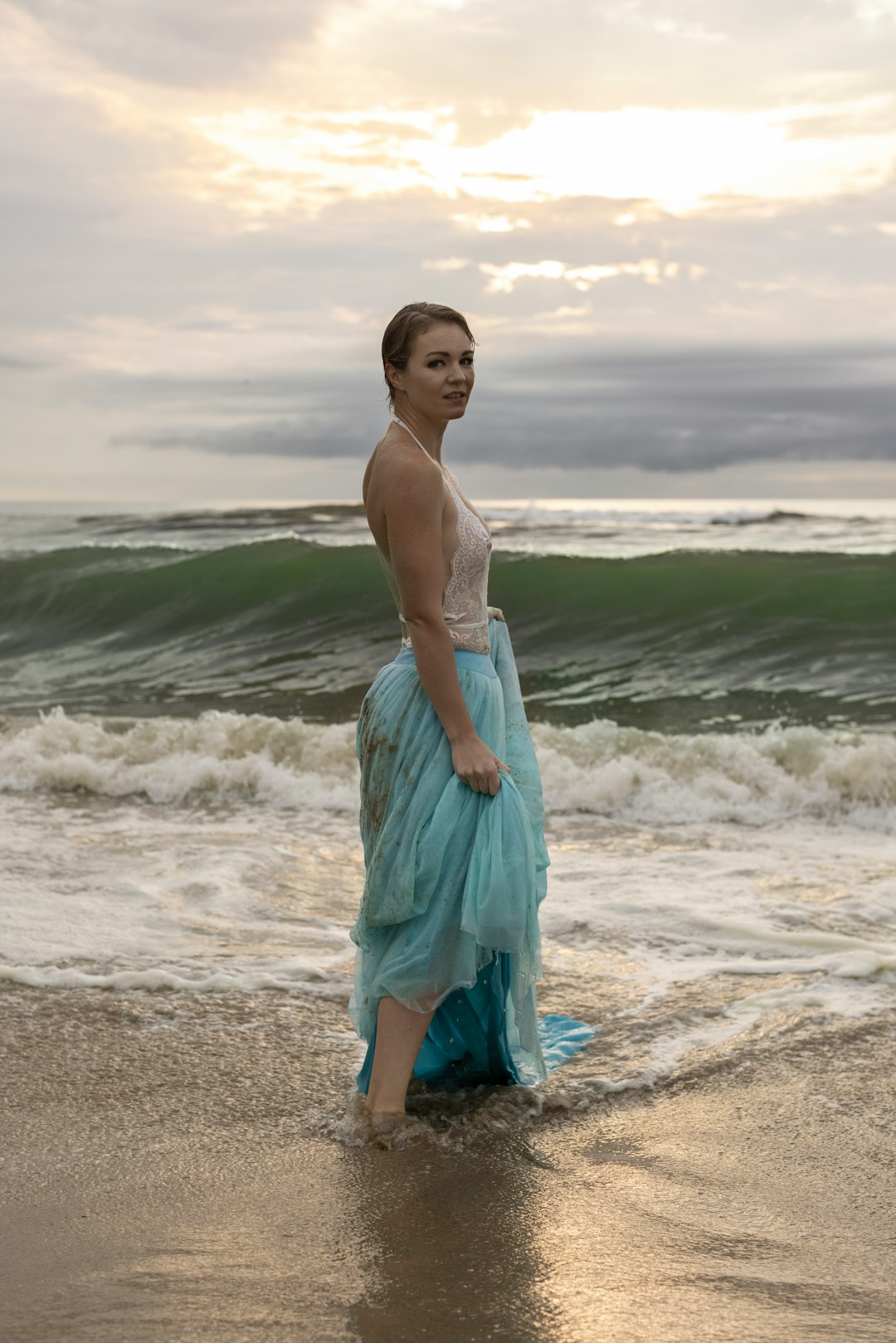 woman in blue dress standing on beach during daytime