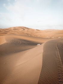 brown sand dunes under blue sky during daytime
