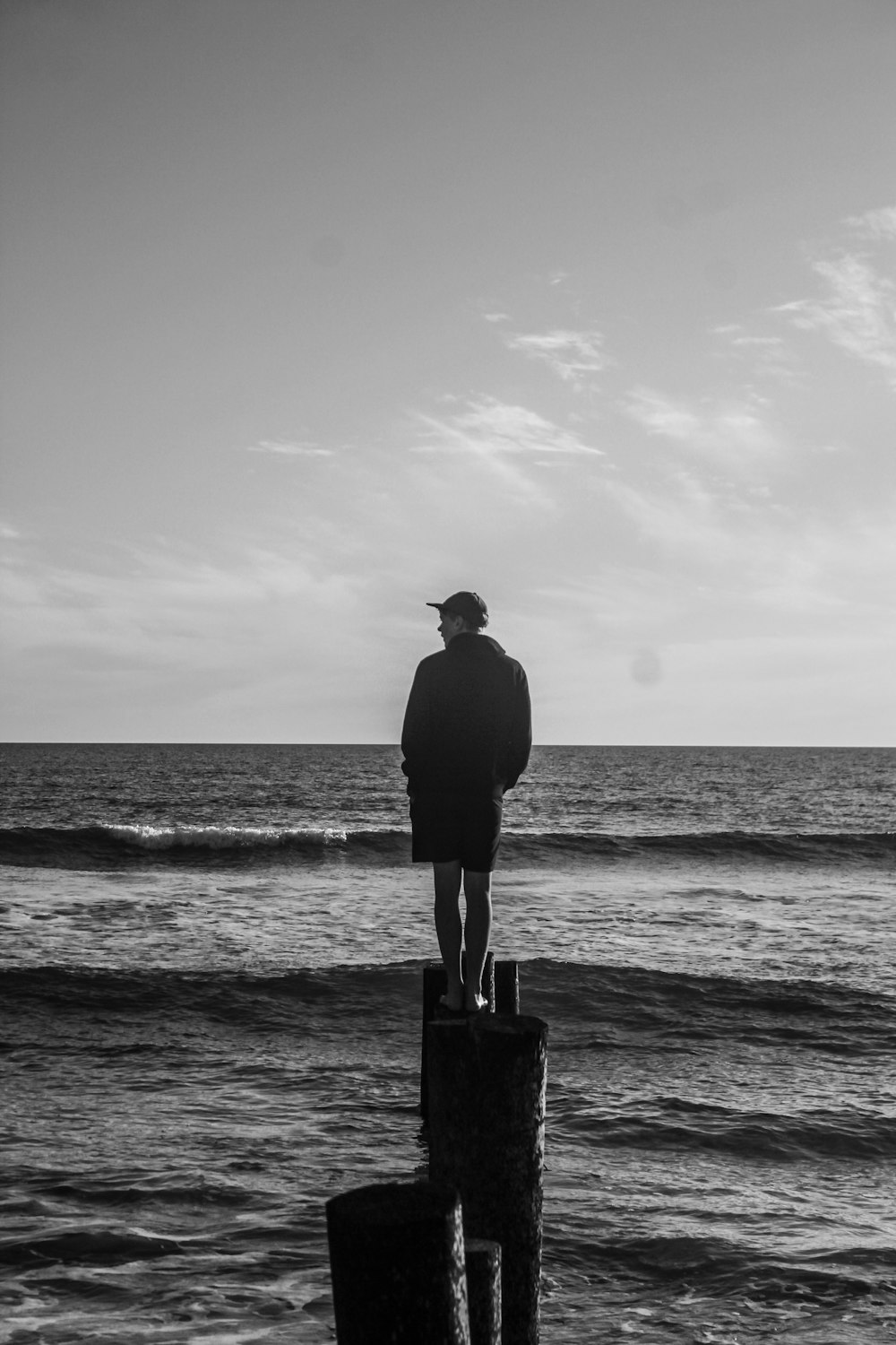 man standing on rock near body of water