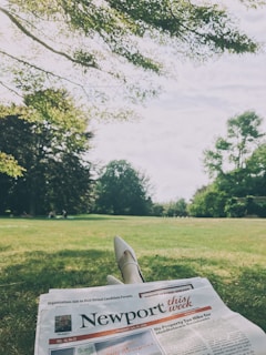 A peaceful moment with Alicia reading a newspaper in a park.