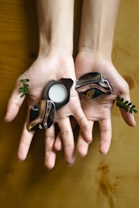 Close-up of hands holding symbolic objects used in systemic family constellation therapy.
