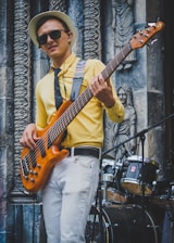man in yellow polo shirt playing brown electric guitar
