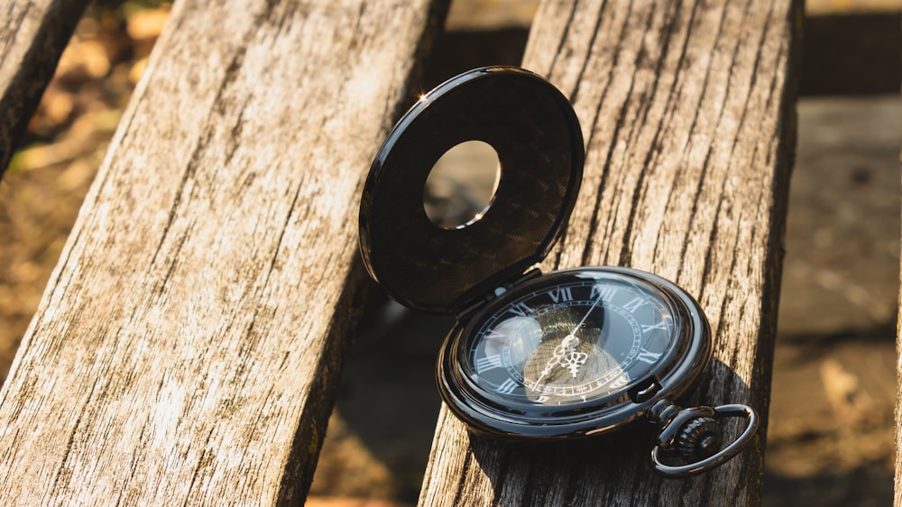 black and silver compass on brown wooden table