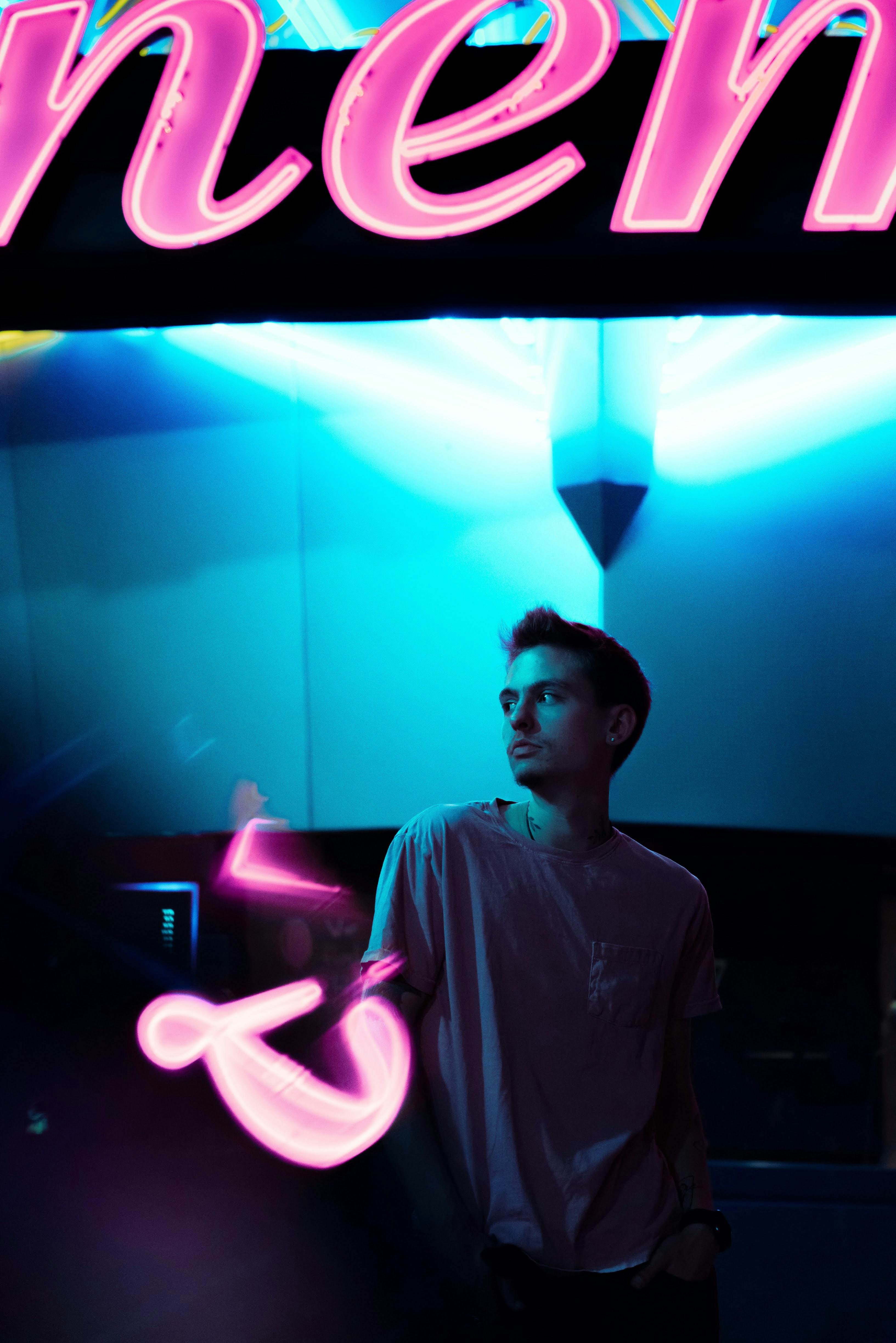 man in gray dress shirt standing in front of green light