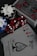 A collection of poker chips, red dice, and a deck of playing cards is arranged on a dark surface. The cards include an ace of spades with intricate black artwork and a standard Bicycle design. The set includes black, white, and blue poker chips featuring the Bicycle brand name.