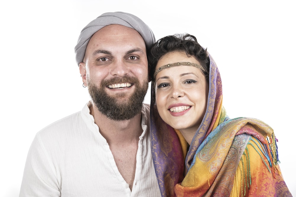 man in white shirt beside woman in orange and yellow scarf